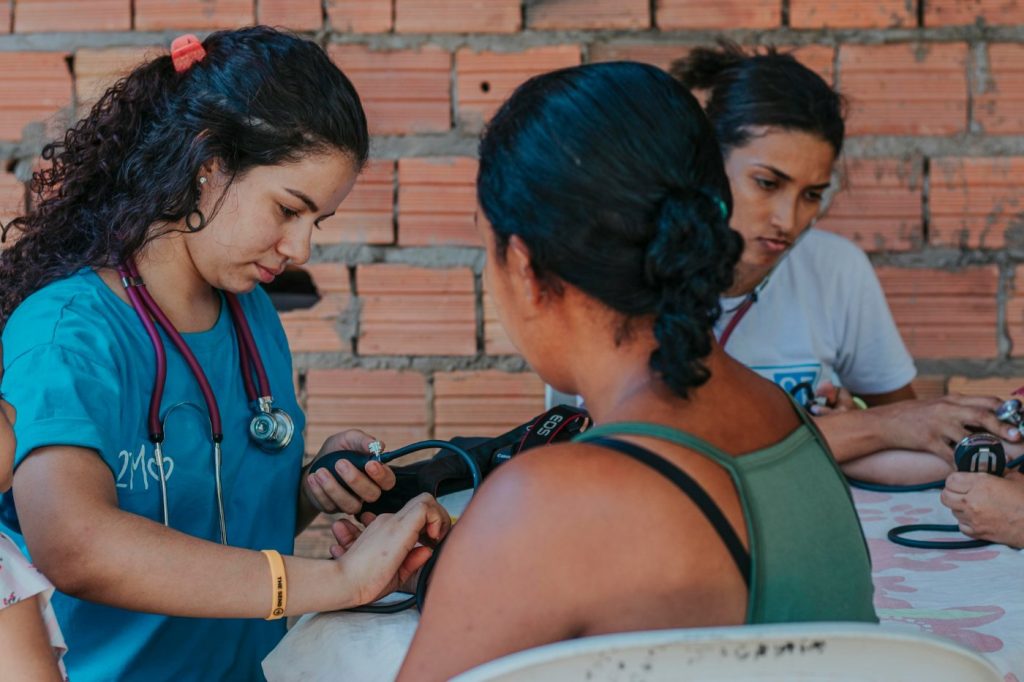 Health worker checking a woman's blood pressure at a community clinic